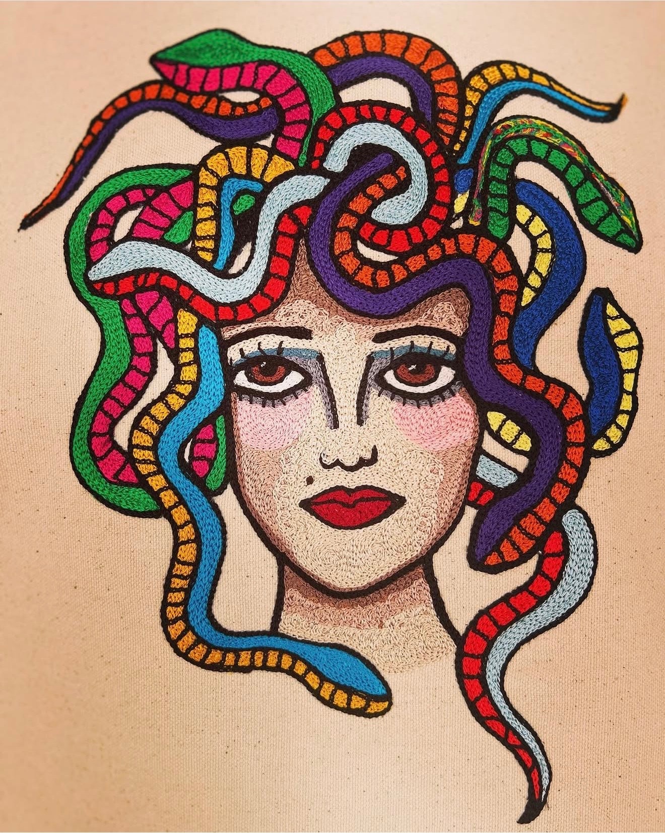 Embroidered portrait with colorful snake hair